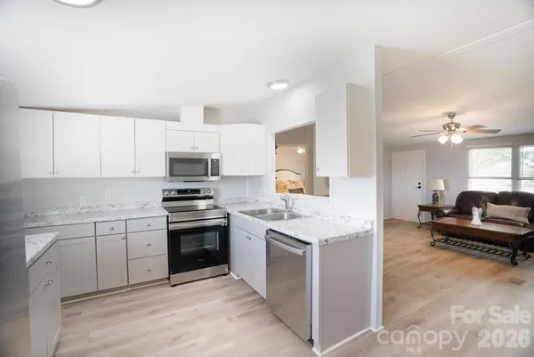a kitchen with granite countertop a sink stainless steel appliances and cabinets