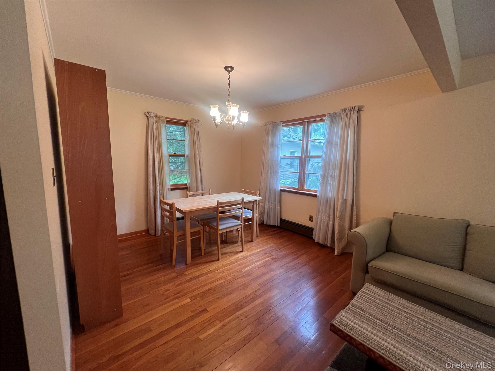 4 Beach Road, Unit G Glen Spey, NY 12737 - Photo 3 of 16 a living room with furniture a chandelier and a dining table with wooden floor