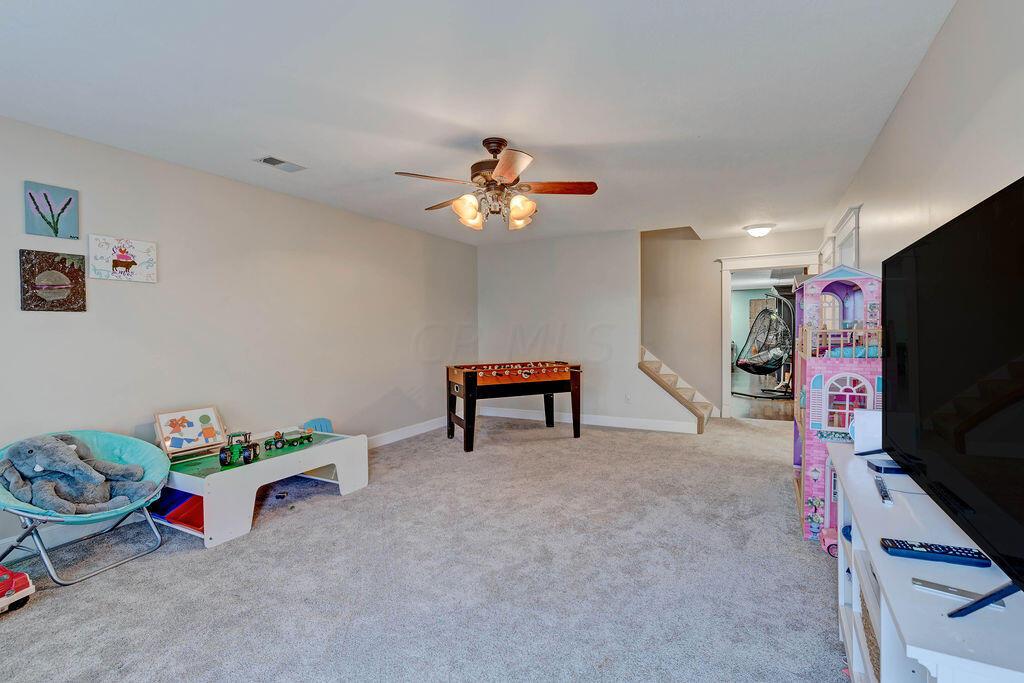 4045 Russell Road Mount Gilead, OH 43338 - Photo 36 of 74 • Gray carpet • Tan painted walls • Lighted ceiling fan • Window with door