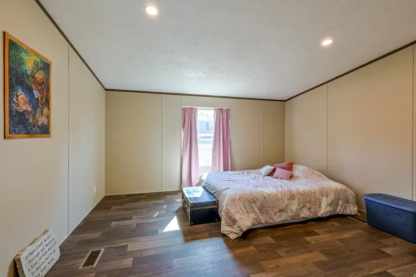 a bedroom with a bed and wooden floor