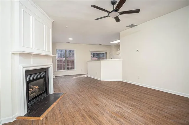 a view of empty room with wooden floor and fireplace