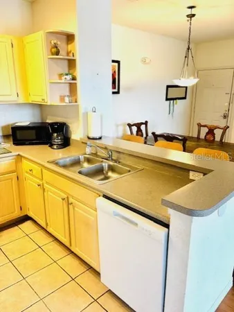 a bed sitting in a bedroom next to a window and a chandelier