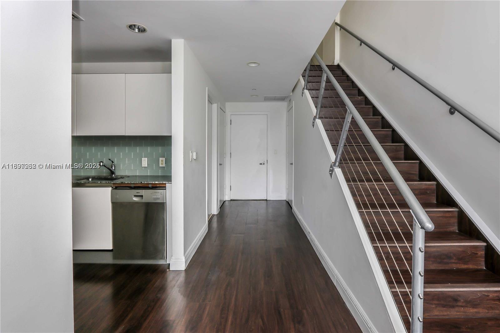 1050 Brickell Avenue, Unit 414 Miami, FL 33131 - Photo 6 of 42 a view of an empty room with wooden floor and stairs