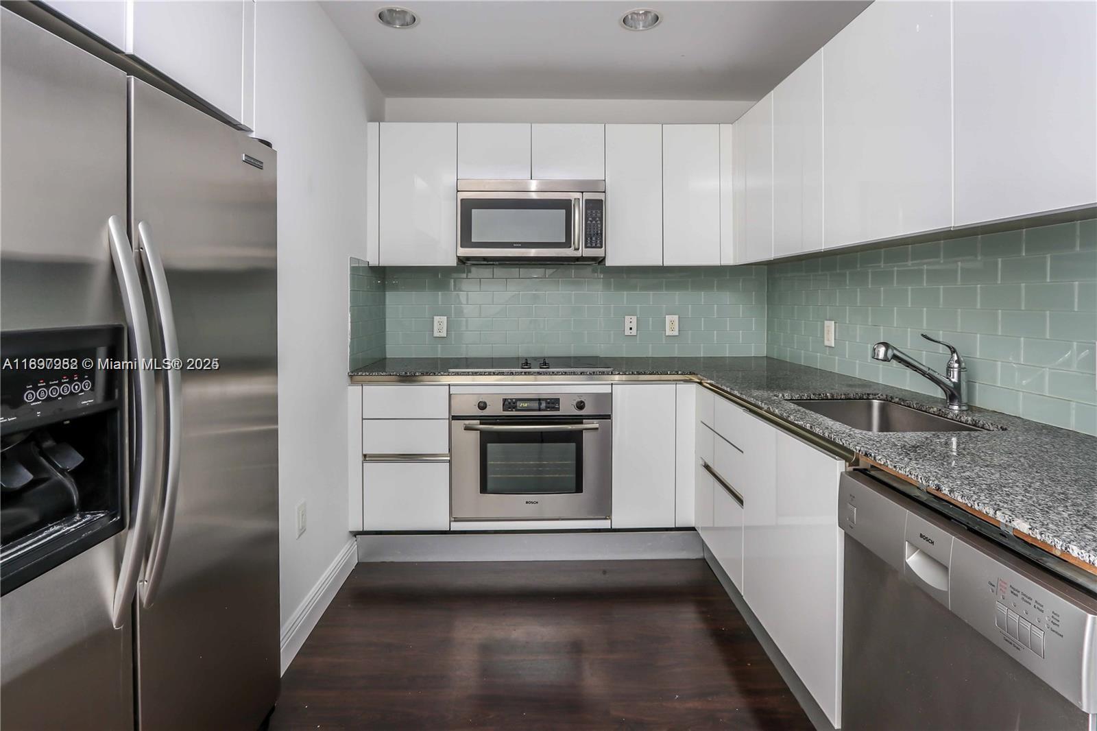 1050 Brickell Avenue, Unit 414 Miami, FL 33131 - Photo 8 of 42 a kitchen with a sink and steel stainless steel appliances