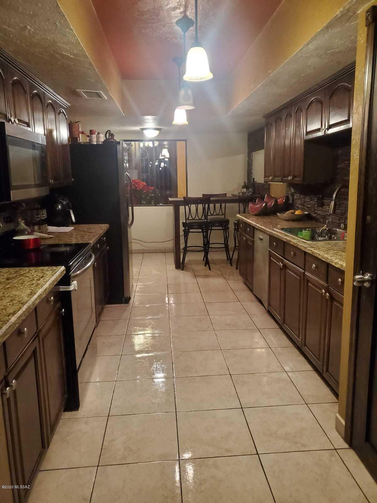 1186 Avenida Leon Rio Rico, AZ 85648 - Photo 15 of 31 a kitchen with stainless steel appliances granite countertop a stove a sink and a microwave