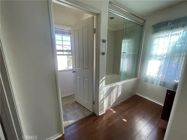 a bathroom with a tub shower and window