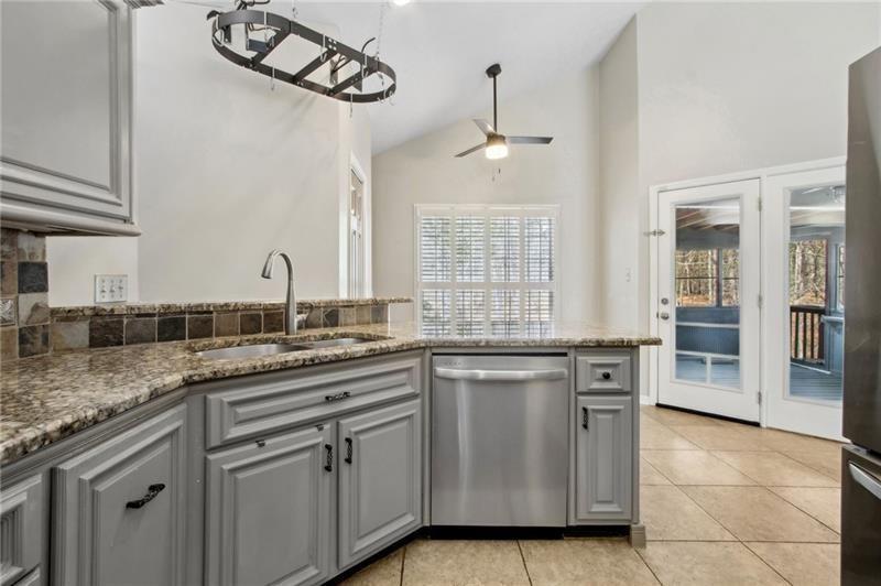 6604 Windbrook Way Flowery Branch, GA 30542 - Photo 23 of 64 a kitchen with stainless steel appliances granite countertop a sink and dishwasher a stove with wooden cabinets