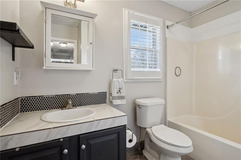 6604 Windbrook Way Flowery Branch, GA 30542 - Photo 38 of 64 a bathroom with a granite countertop toilet a sink and a mirror