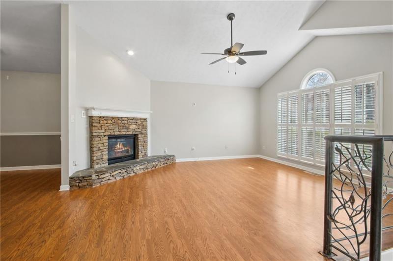 6604 Windbrook Way Flowery Branch, GA 30542 - Photo 8 of 64 a view of an empty room with wooden floor fireplace and a window