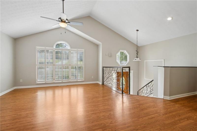 6604 Windbrook Way Flowery Branch, GA 30542 - Photo 10 of 64 a view of an empty room with wooden floor and a window