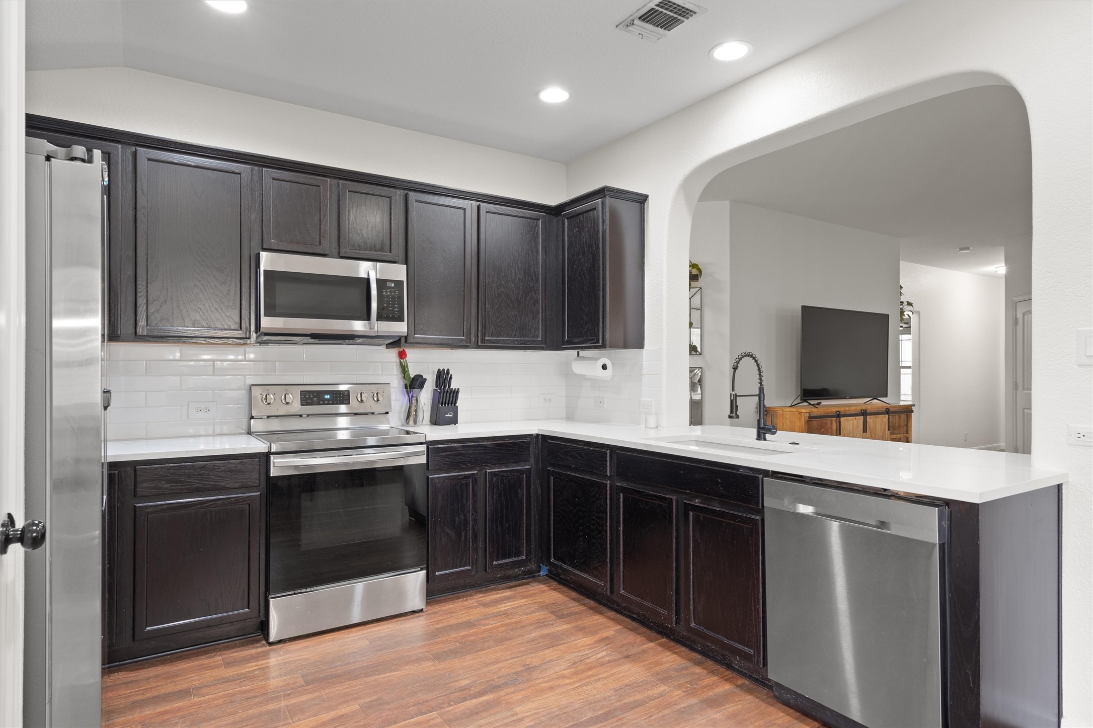 606 Old Peak Road Georgetown, TX 78626 - Photo 6 of 23 Kitchen featuring dark wood-finish cabinetry, white countertops, subway tile backsplash, and stainless steel appliances