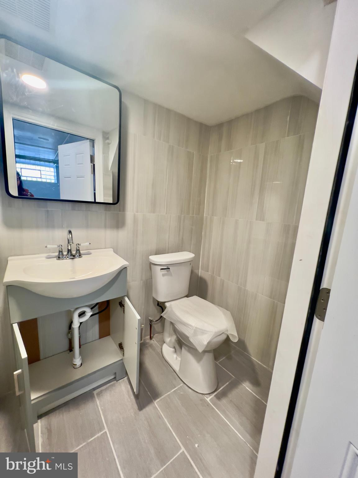 124 West Spencer Street Philadelphia, PA 19120 - Photo 27 of 34 a bathroom with a sink toilet and mirror