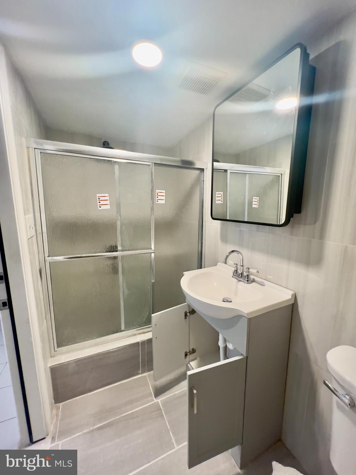 124 West Spencer Street Philadelphia, PA 19120 - Photo 28 of 34 a bathroom with a sink a toilet a mirror and vanity