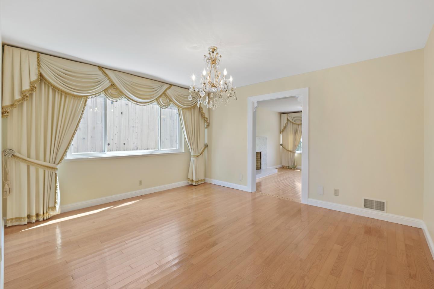 750 Clearfield Drive Millbrae, CA 94030 - Photo 11 of 35 a view of a hallway with wooden floor and a chandelier