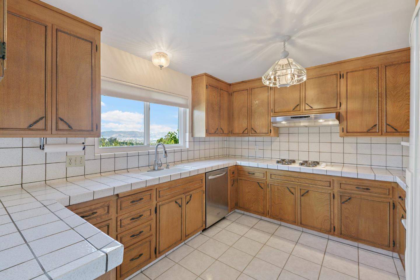 750 Clearfield Drive Millbrae, CA 94030 - Photo 12 of 35 a kitchen with sink cabinets and window