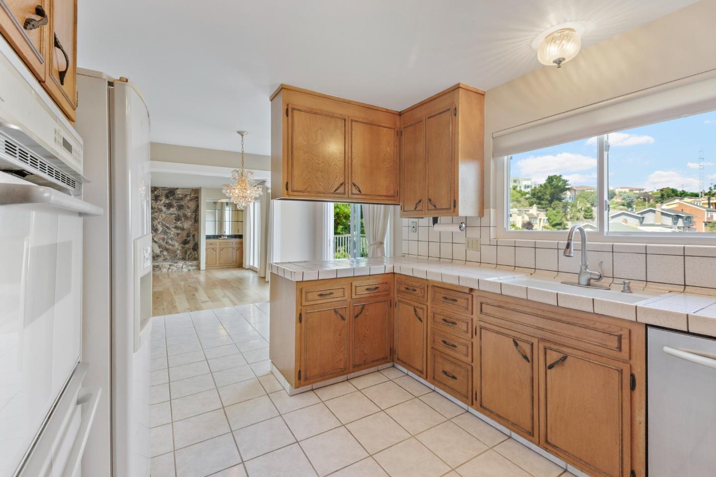 750 Clearfield Drive Millbrae, CA 94030 - Photo 15 of 35 a large kitchen with white cabinets a sink a window and stainless steel appliances