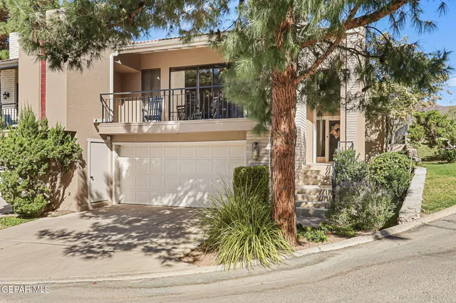 a view of a tennis ground with large trees