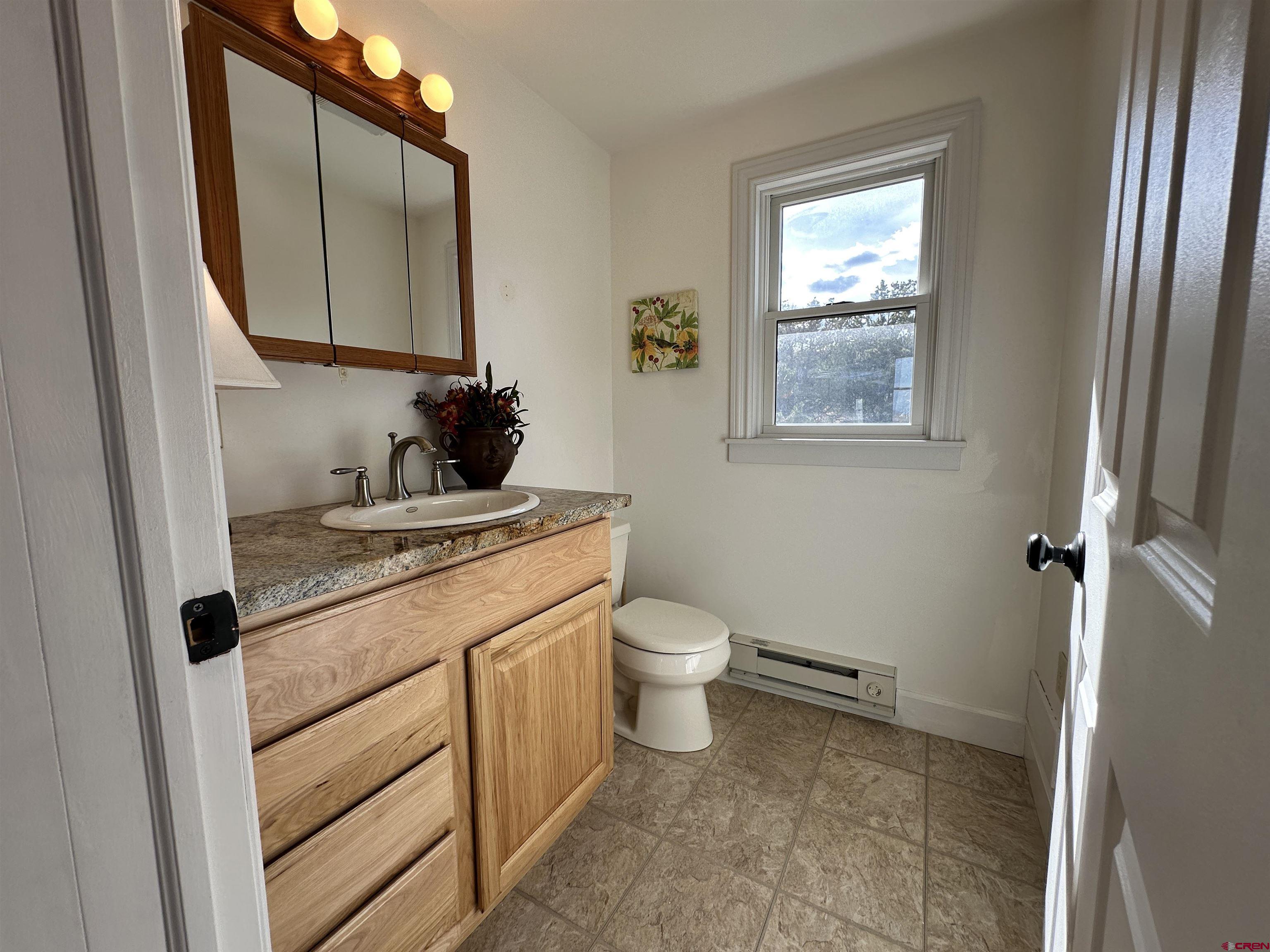 351 Loveland Road South Fork, CO 81154 - Photo 13 of 45 a bathroom with a granite countertop toilet sink and mirror