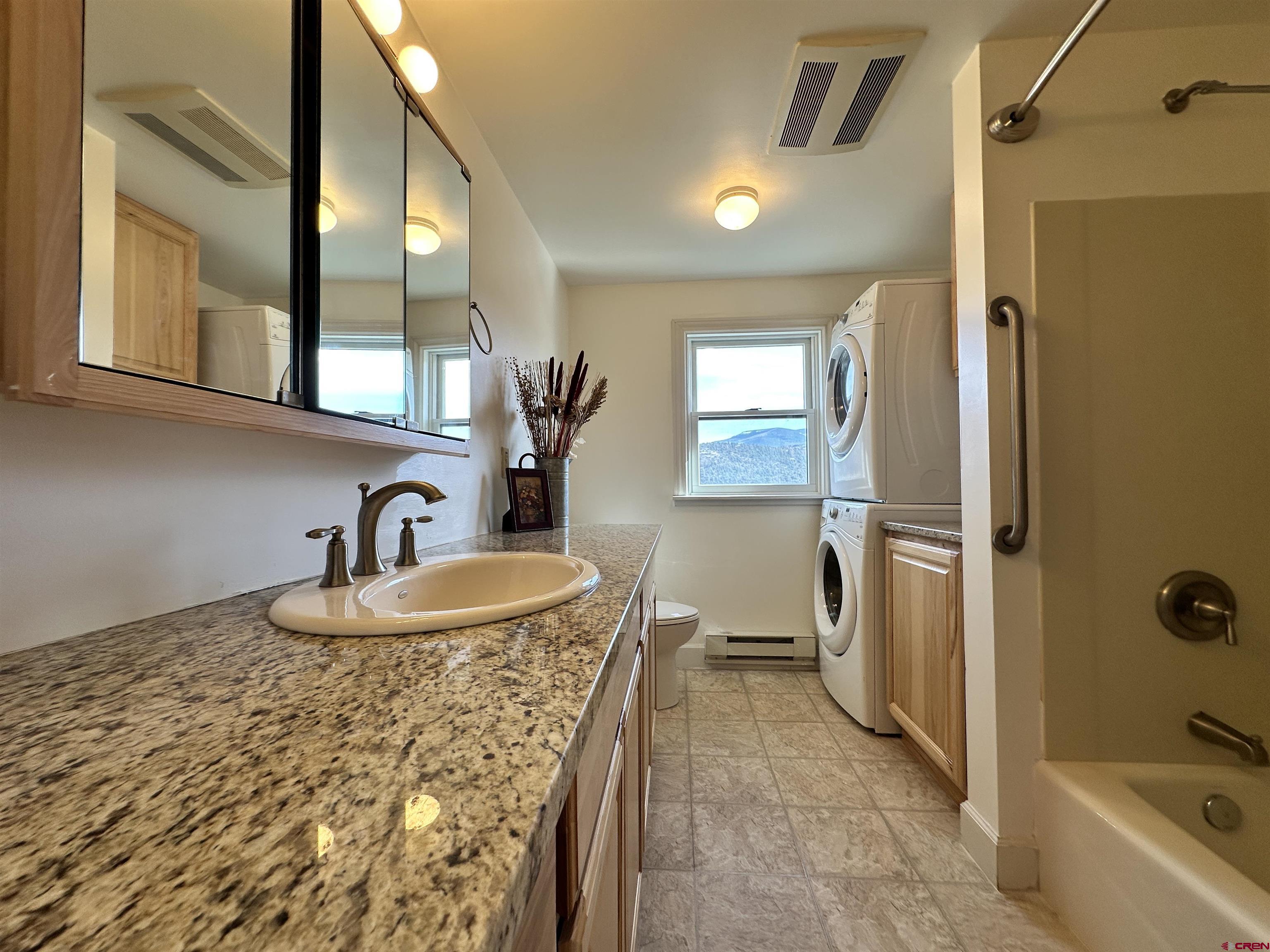 351 Loveland Road South Fork, CO 81154 - Photo 22 of 45 a bathroom with a granite countertop sink a toilet and shower