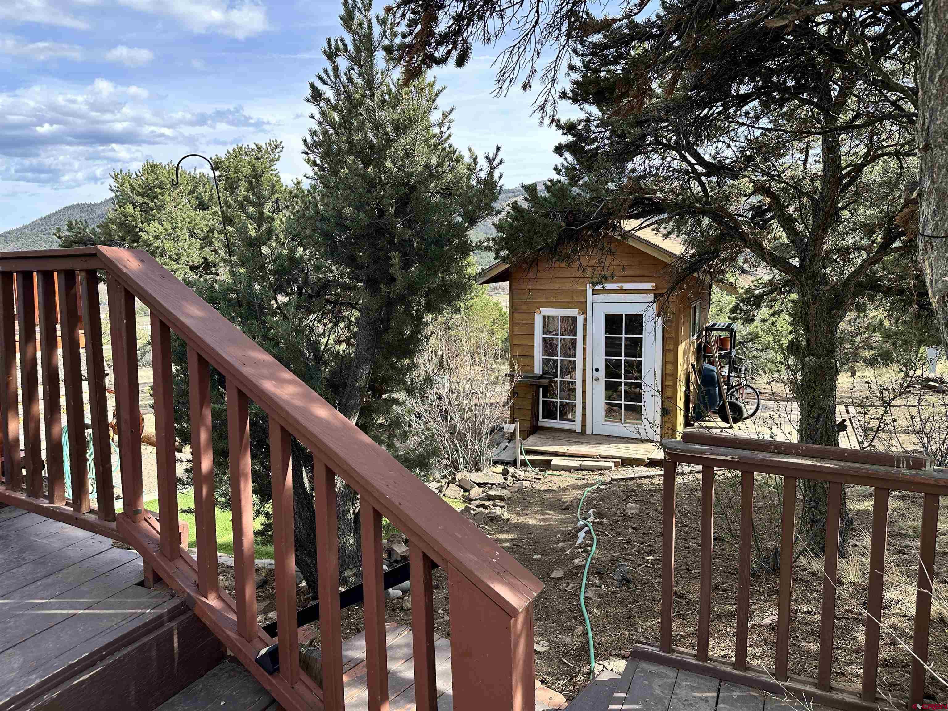 351 Loveland Road South Fork, CO 81154 - Photo 41 of 45 a view of a wooden house with large trees and stairs