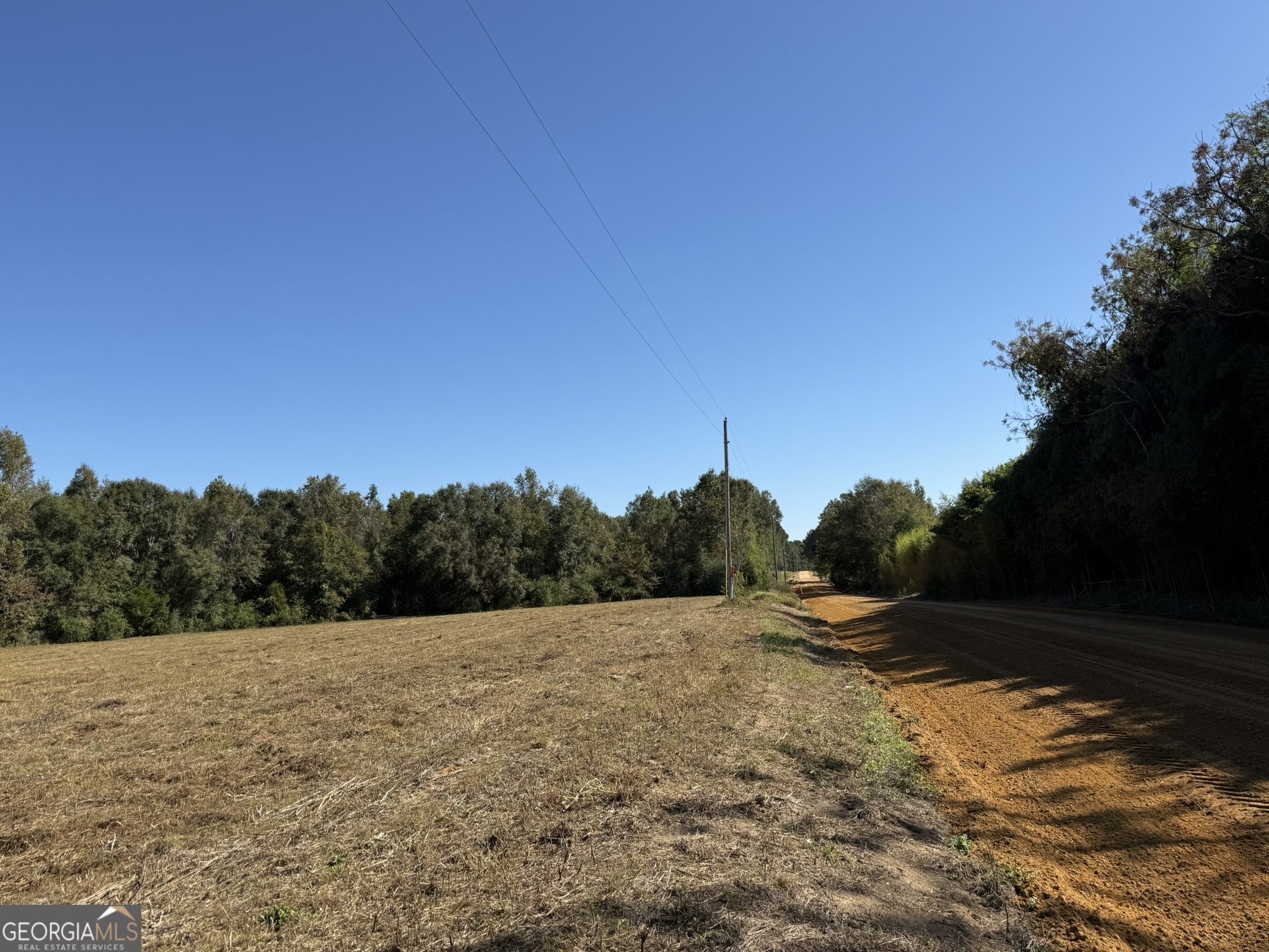a view of a field with a wooden fence