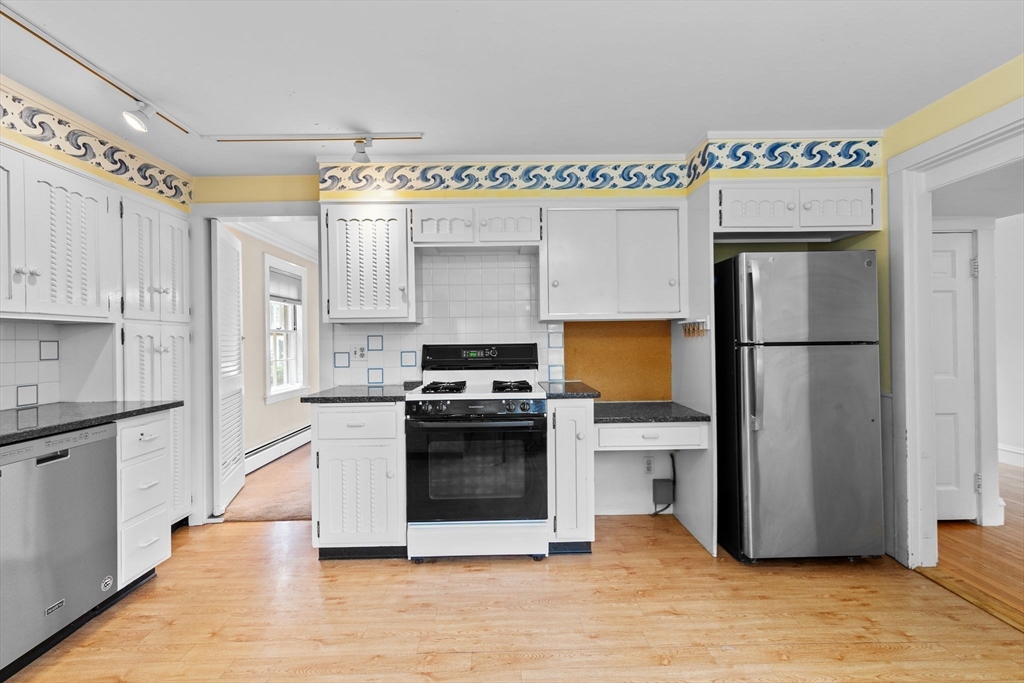 26 Holman Road Newton, MA 02466 - Photo 11 of 42 a kitchen with stainless steel appliances a refrigerator sink and cabinets