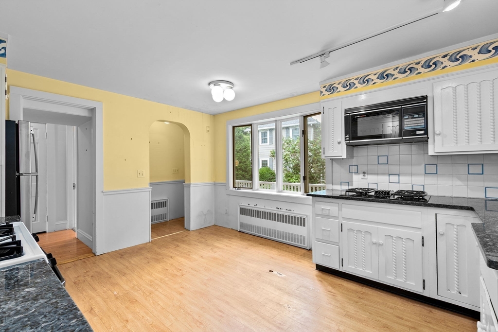 26 Holman Road Newton, MA 02466 - Photo 13 of 42 a kitchen with granite countertop a stove a sink and a microwave