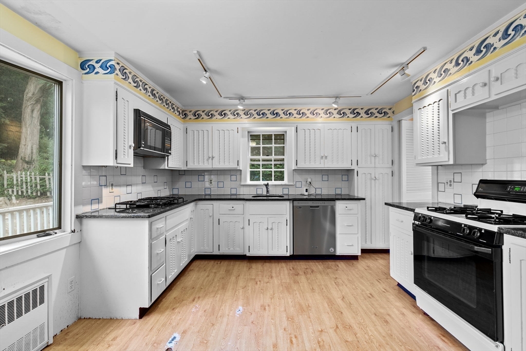 26 Holman Road Newton, MA 02466 - Photo 9 of 42 a kitchen with stainless steel appliances granite countertop a stove and a sink