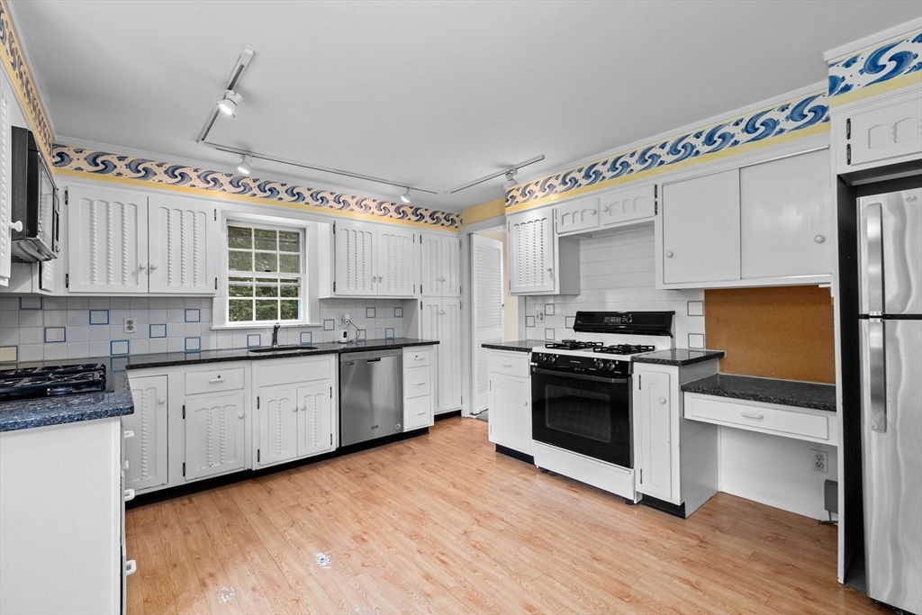 26 Holman Road Newton, MA 02466 - Photo 10 of 42 a kitchen with stainless steel appliances granite countertop a stove and a refrigerator