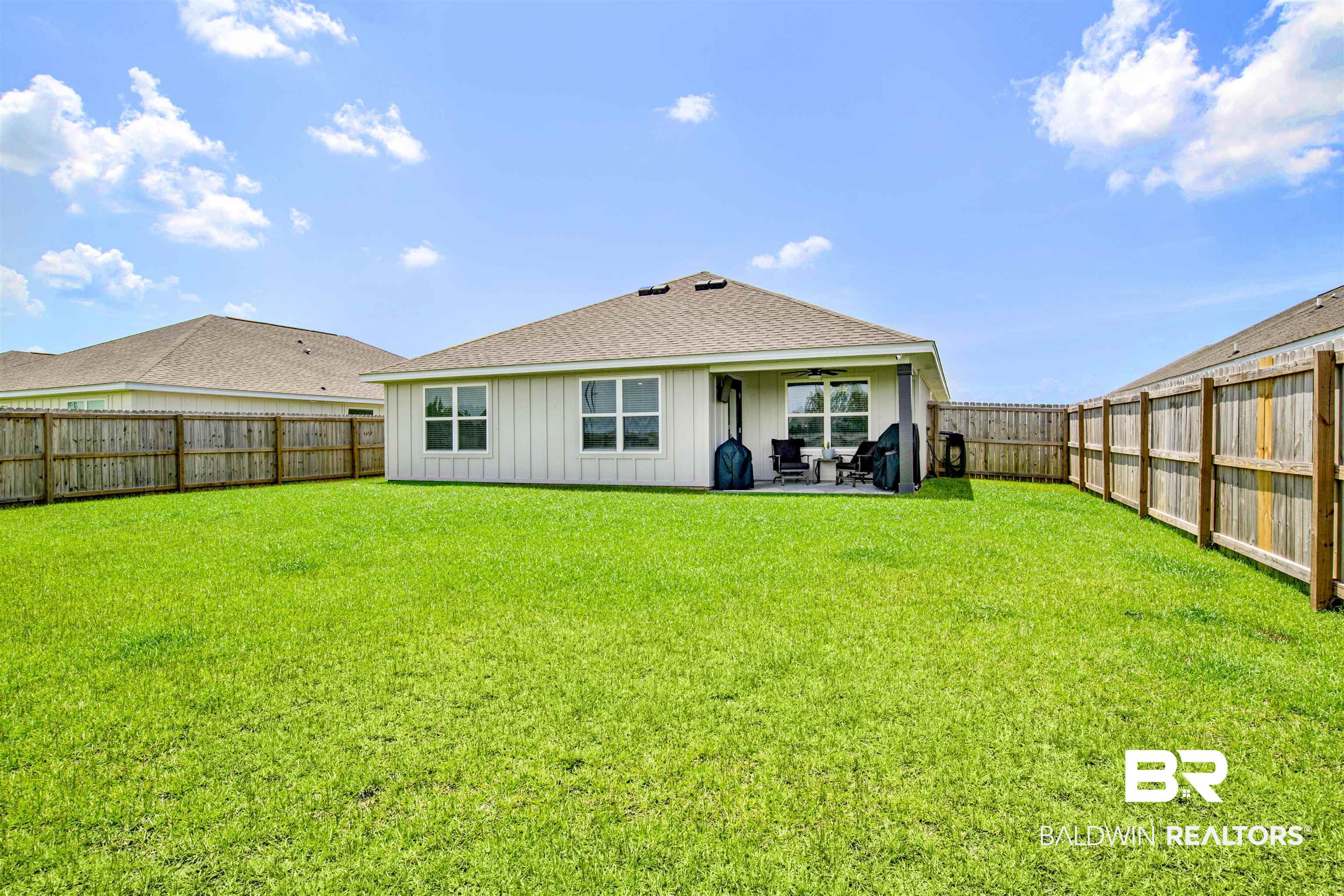 14731 Forsythia Loop Silverhill, AL 36576 - Photo 22 of 25 Rear view of house featuring a patio and a lawn