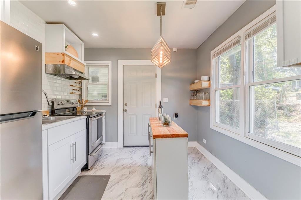 2005 Highland Circle Rome, GA 30161 - Photo 2 of 36 a kitchen with stainless steel appliances granite countertop a refrigerator a sink dishwasher a stove and a dining table with wooden floor