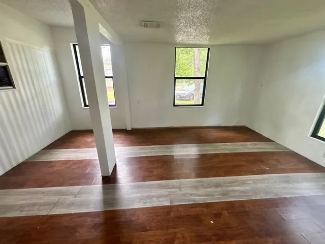 an empty room with wooden floor and entrance