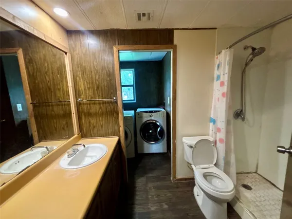 a bathroom with a sink a toilet and shower