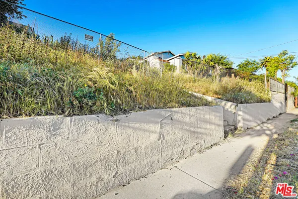 a view of a dry yard with wooden fence