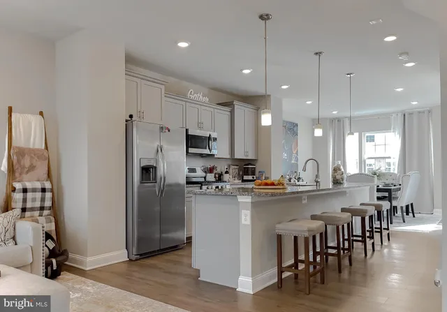 a kitchen with kitchen island a refrigerator a stove a dining table and chairs