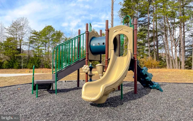 a front view of a house with a garden and trees