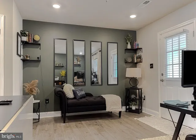 a living room with furniture a flat screen tv and a large window
