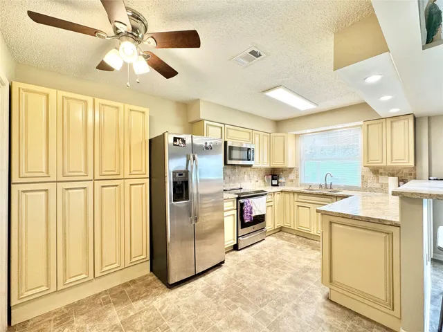 a kitchen with refrigerator cabinets and ceiling fan