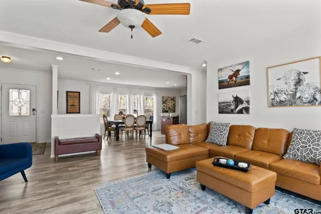 a living room with furniture and a dining table with kitchen view