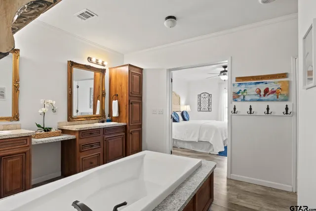 a view of a roof deck with table and chairs couches and a barbeque with wooden fence and floor