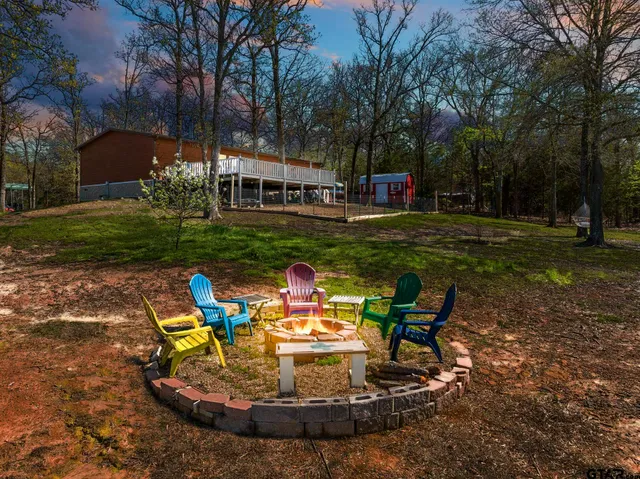 a view of a house with a yard patio and fire pit