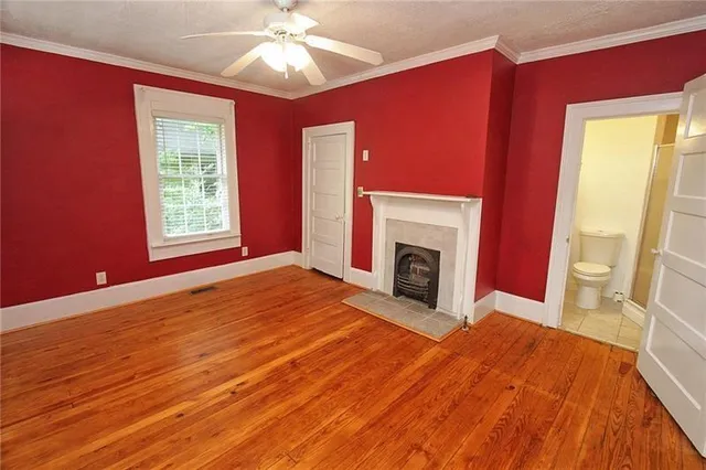 a view of empty room with fireplace and wooden floor