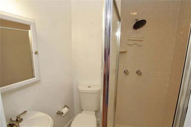 a bathroom with a granite countertop toilet and a shower