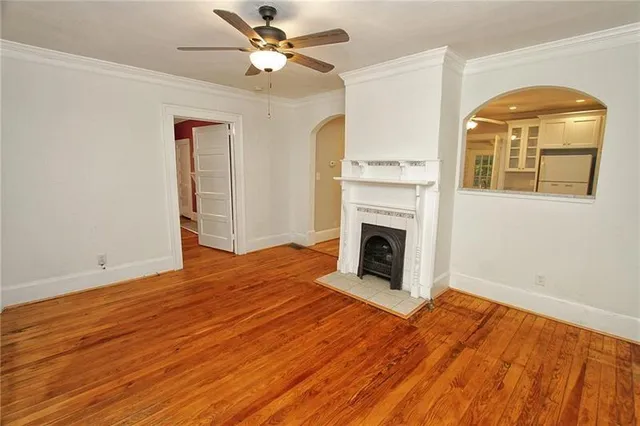 a view of a livingroom with wooden floor and a fireplace