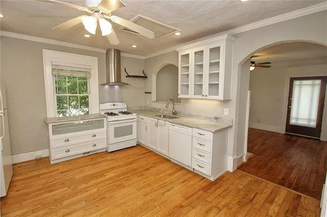 a kitchen with granite countertop white cabinets and white appliances