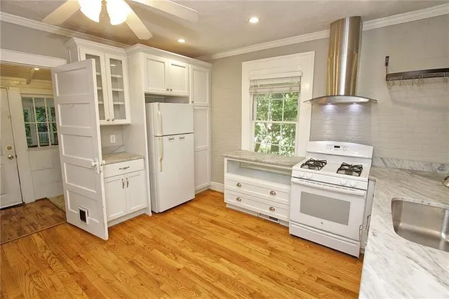 a kitchen with white cabinets and white appliances