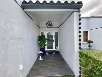a view of a hallway with wooden floor and a potted plant