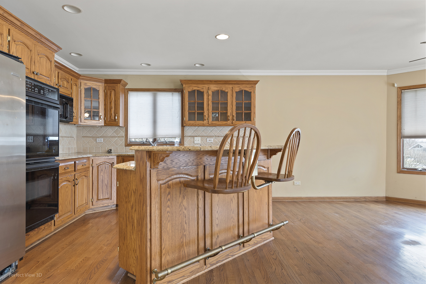 13172 Briar Patch Lane Lemont, IL 60439 - Photo 7 of 26 a kitchen with stainless steel appliances granite countertop a stove a sink a refrigerator white cabinets and wooden floor
