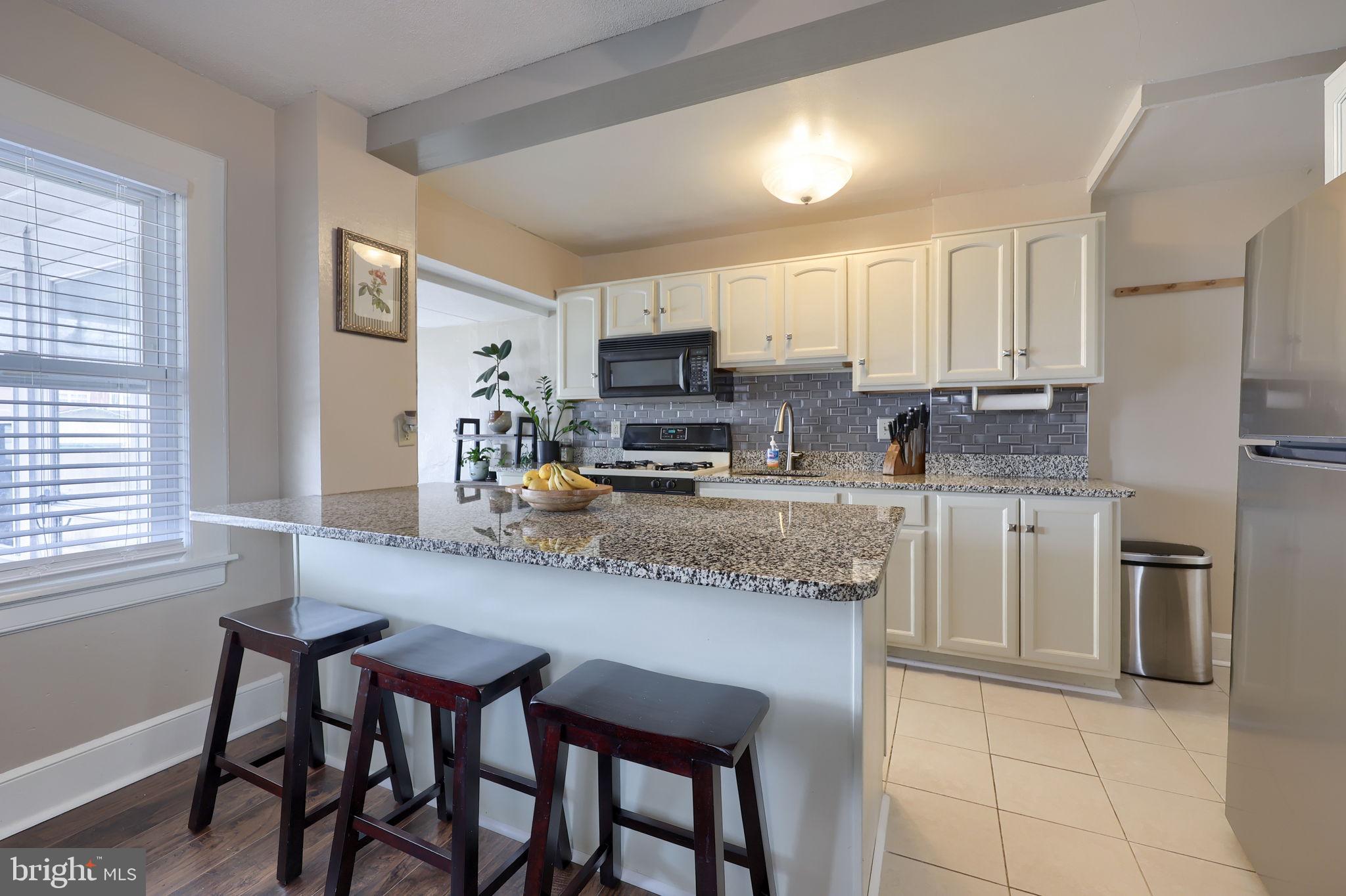 849 Delta Avenue Reading, PA 19605 - Photo 11 of 31 a kitchen with stainless steel appliances granite countertop a stove a sink a microwave a refrigerator and cabinets