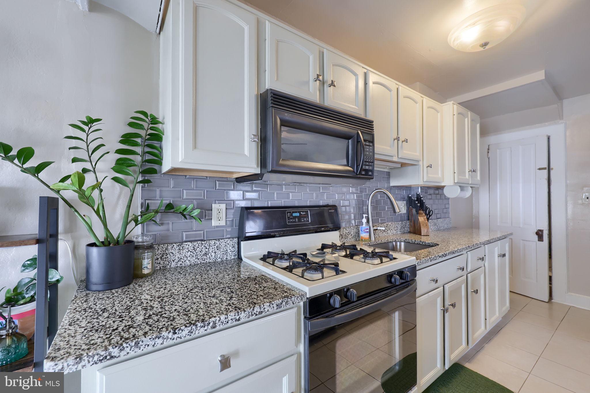 849 Delta Avenue Reading, PA 19605 - Photo 15 of 31 a kitchen with stainless steel appliances kitchen island granite countertop a stove a sink and a microwave